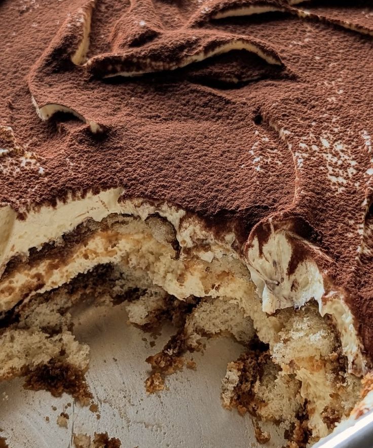 "tiramisu cake layers, topped with cocoa powder"