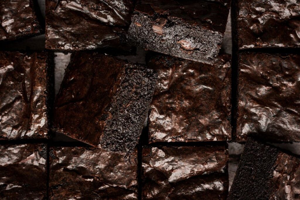 "Close-up of fudgy chocolate brownies with a shiny crackly top"
