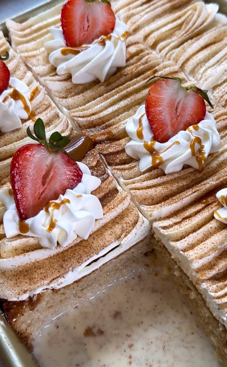 "extra moist tres leches cake topped with whipping cream and strawberries"
